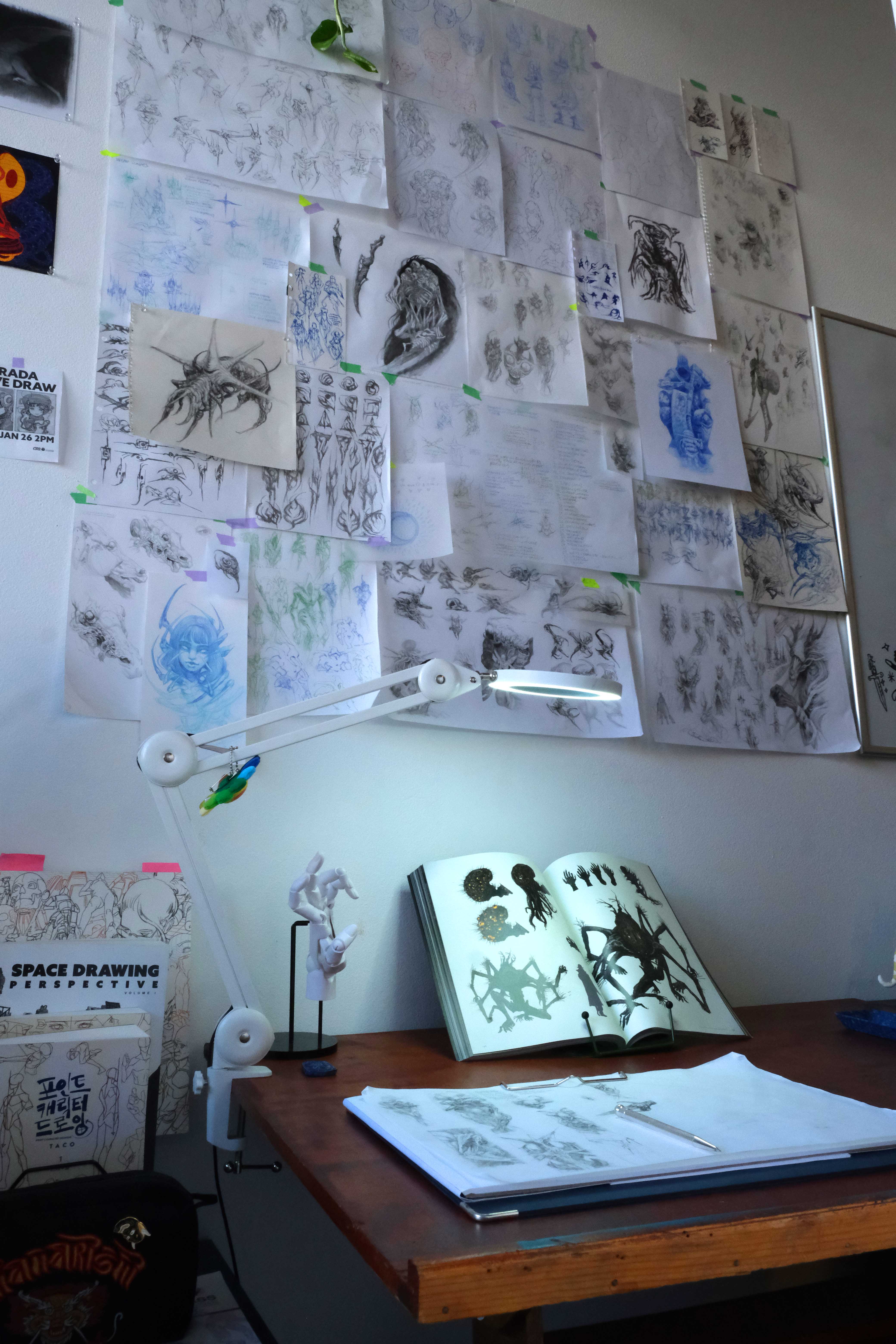 Sketchbook pages pinned to studio wall, dark fantasy reference, Mark Worst