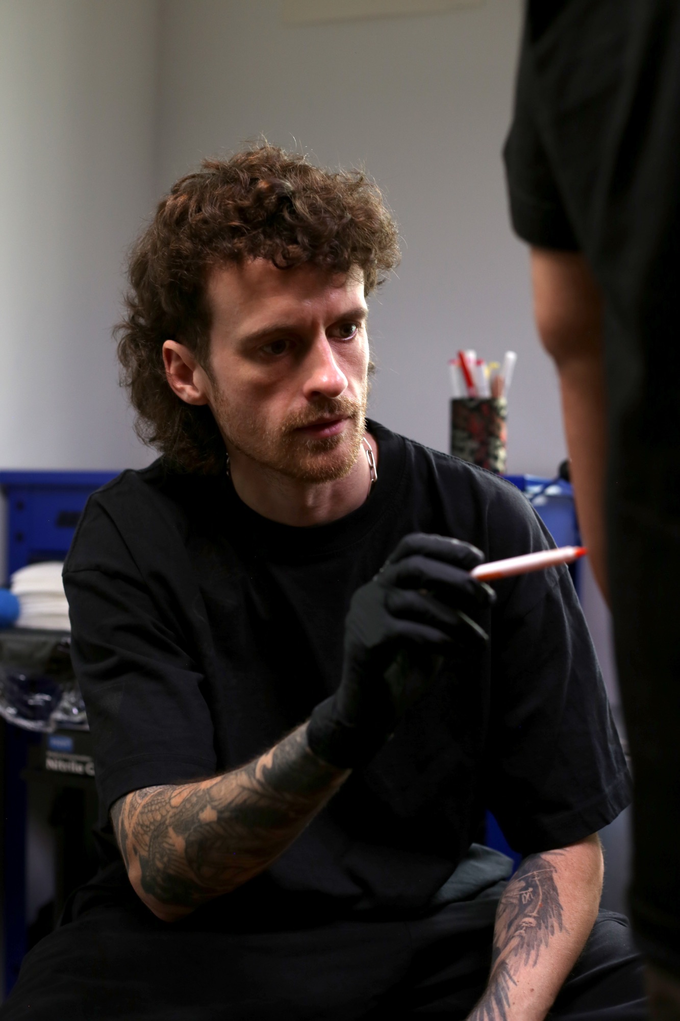 Mark Worst freehand sketching directly on a client in the studio